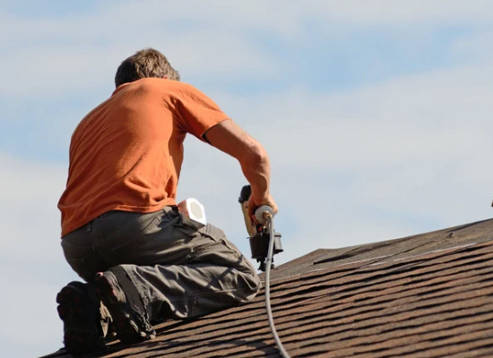 Photo d'un homme en train de travailler sur une toiture